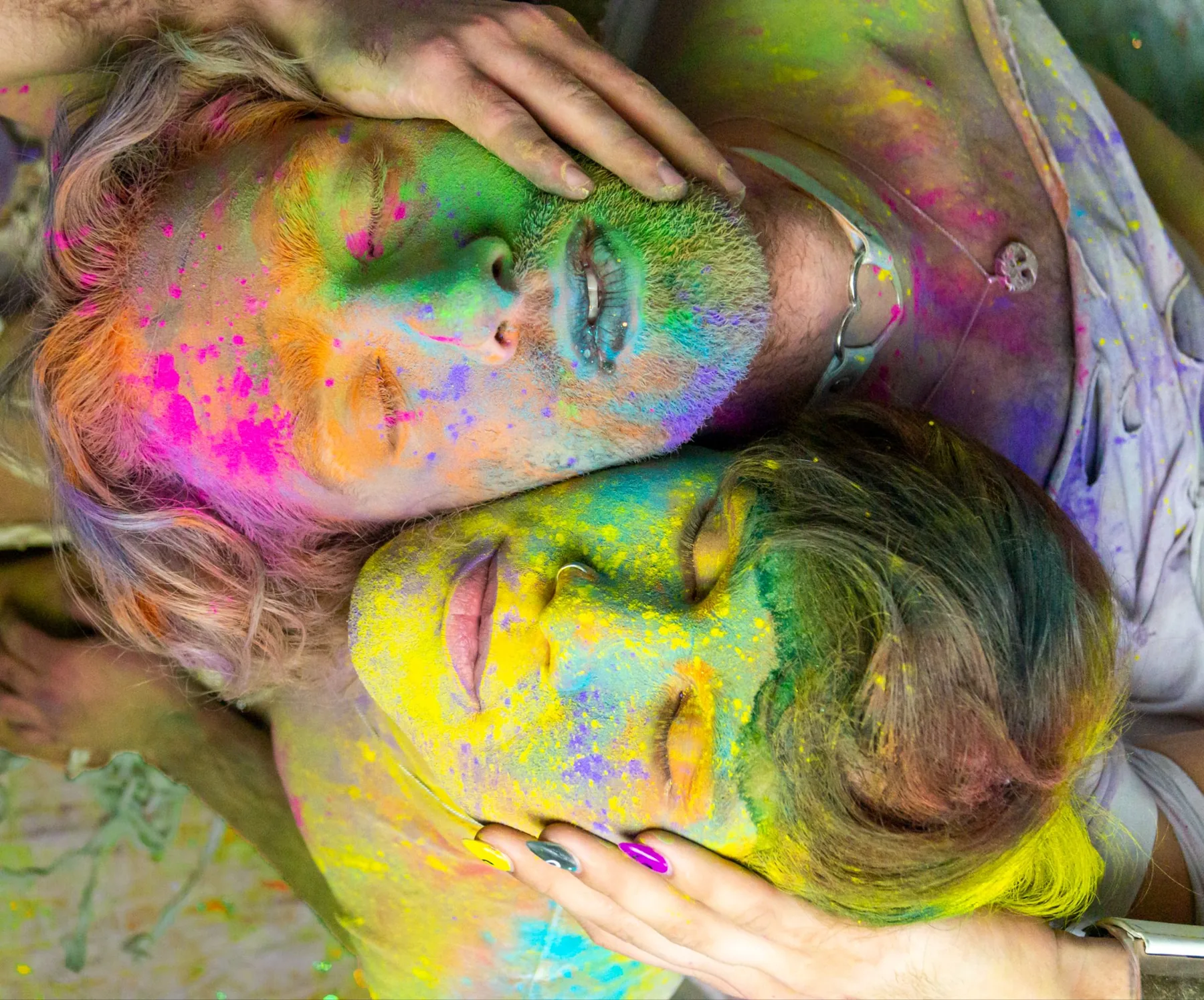 Two faces pressed together, covered in bright powder paint