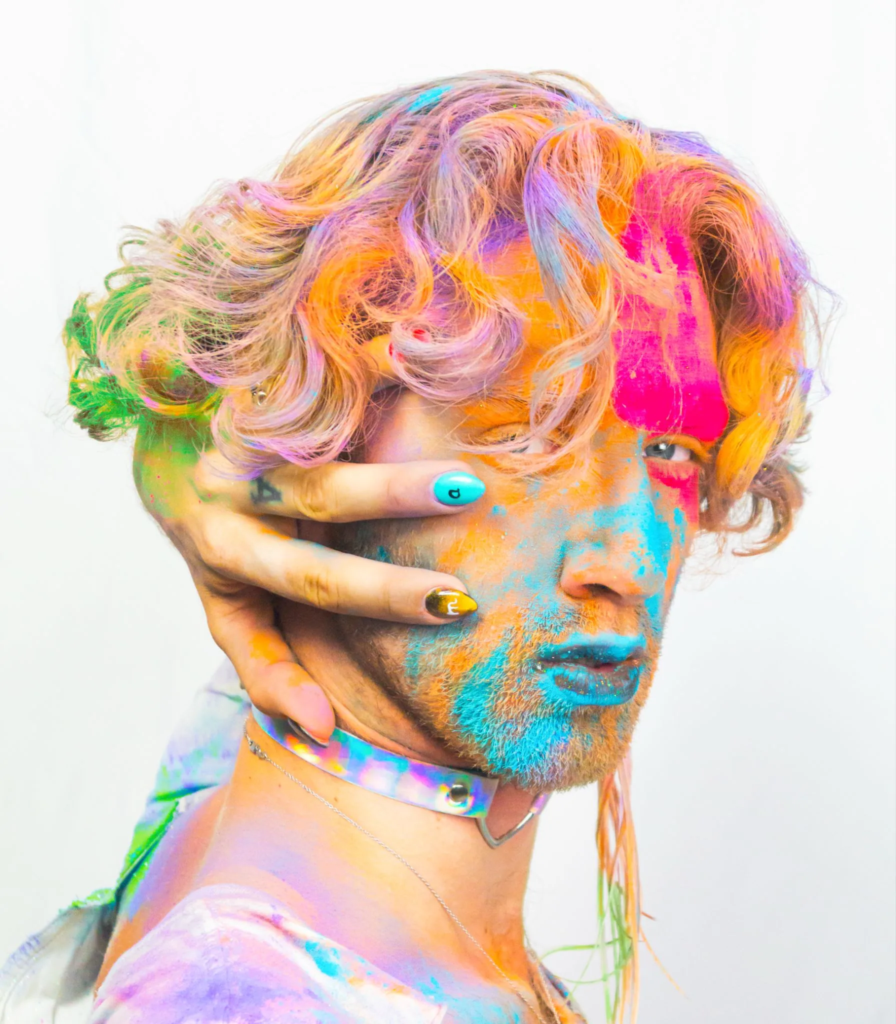 Model with pastel rainbow hair and paint smeared across her face