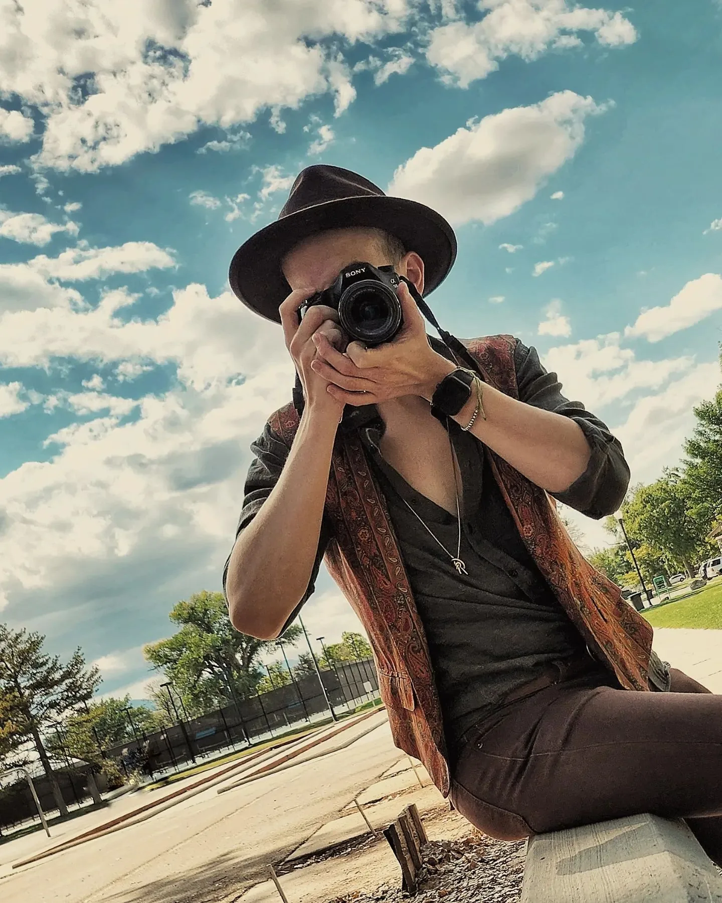 Gabriel Jasmer aiming his camera at the lens, wearing a hat